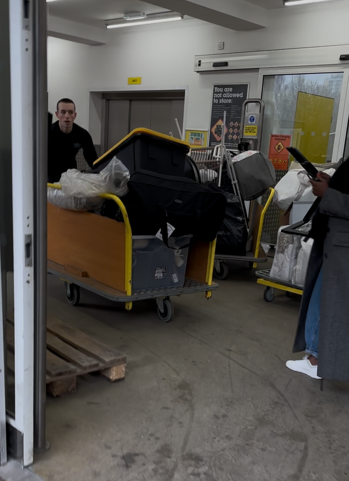 Team members using multiple trolleys in warehouse facility